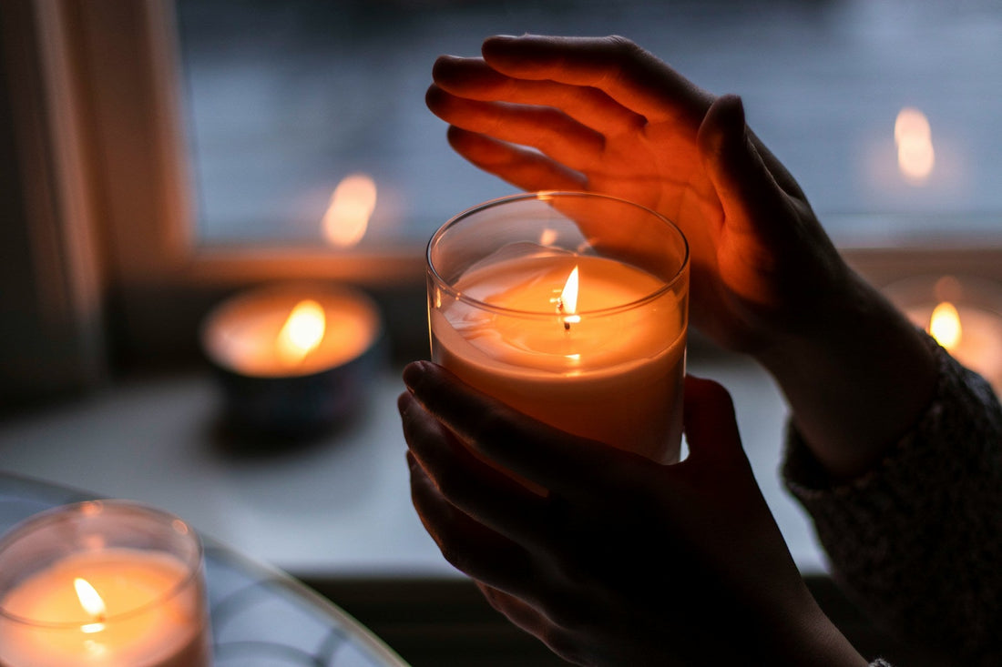 Lit candle burning evenly in a glass jar